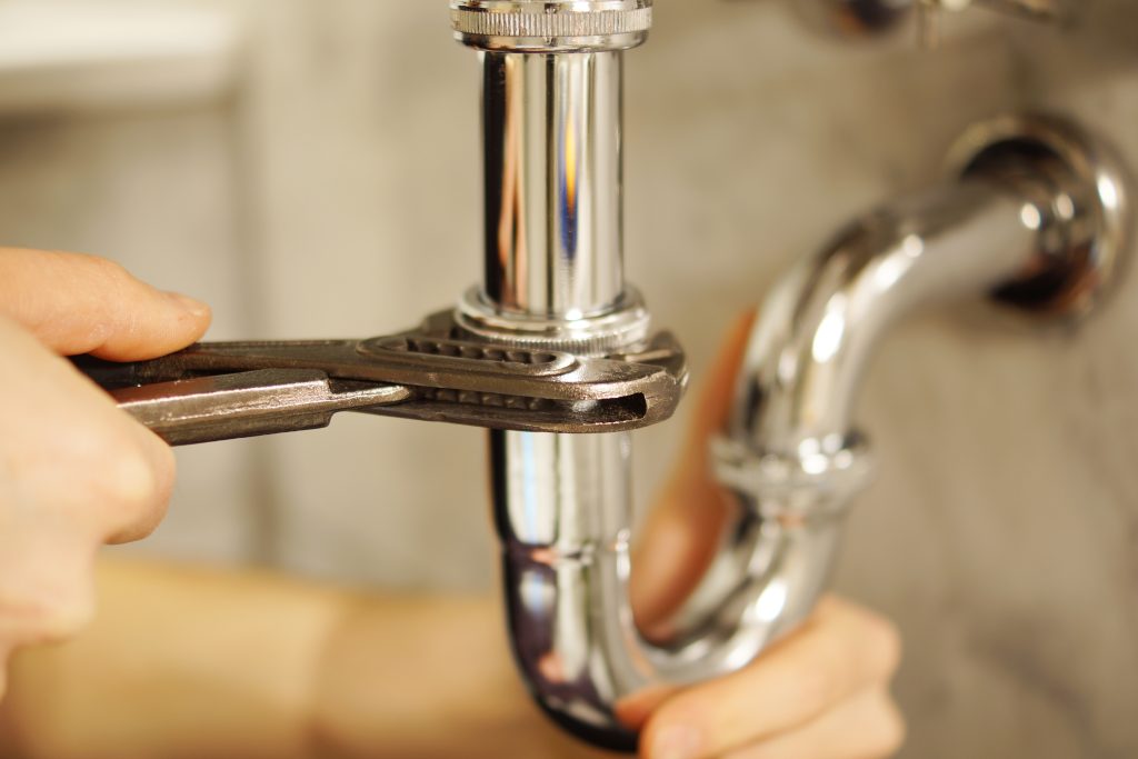 Un plombier professionnel de Flex Plomberie réparant un robinet qui fuit dans une maison à Solliès-Ville. Le technicien utilise des outils spécialisés pour ajuster et remplacer les pièces défectueuses du robinet, garantissant une réparation rapide et efficace.
